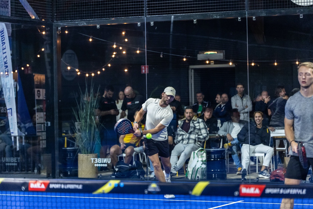 Speler slaat de bal terug op de padelbaan in Zwolle