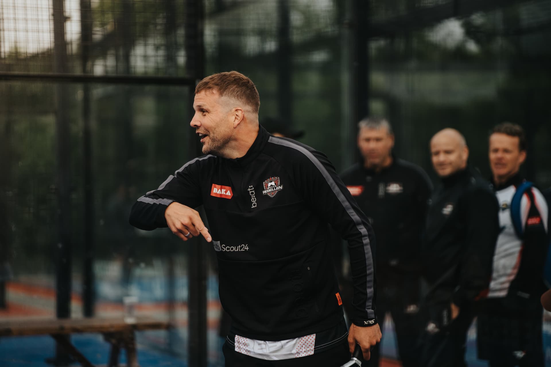 Speler legt iets uit aan zijn team langs de baan