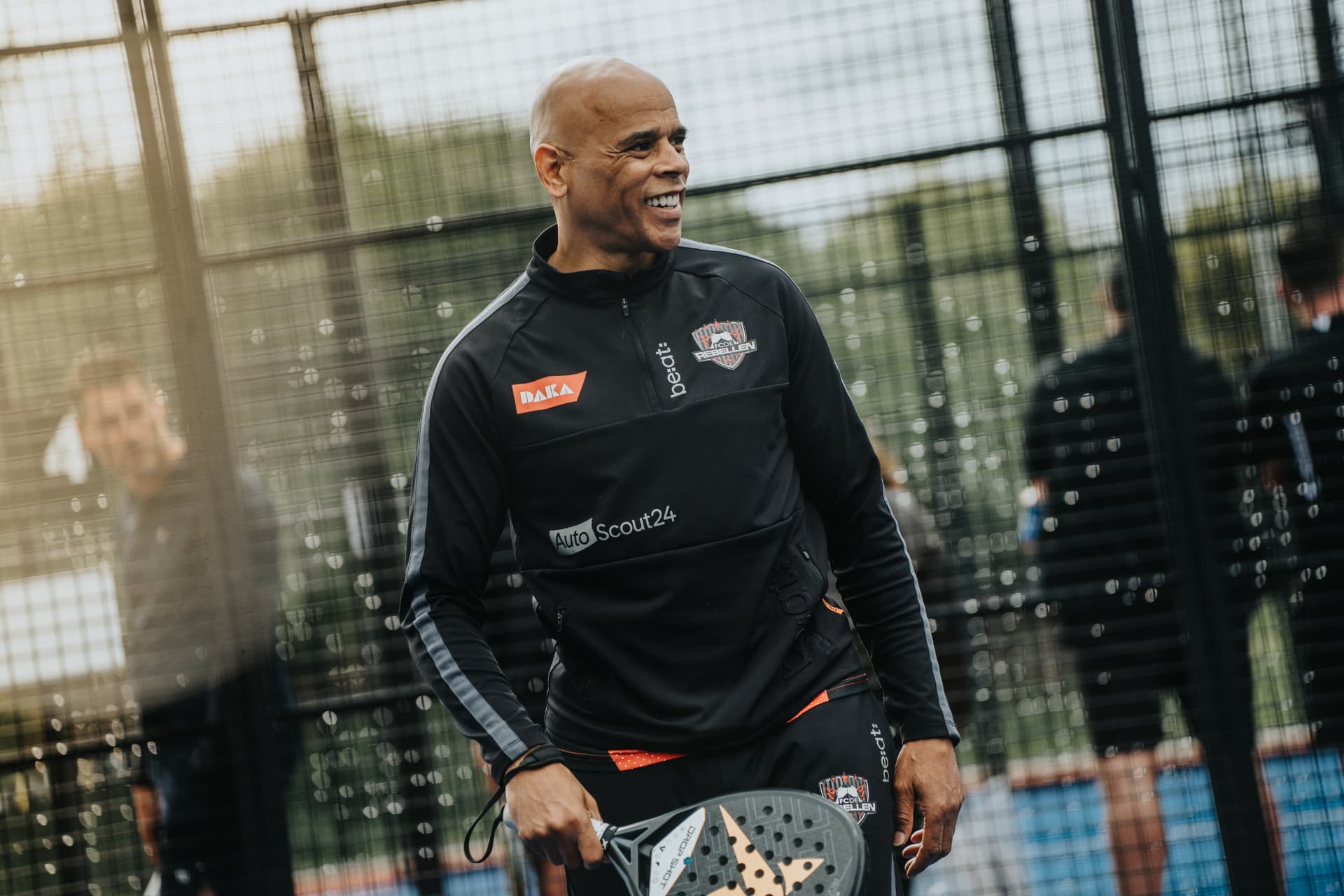 Lachende Rebel met padelracket op de baan tijdens Padellen met de Rebellen